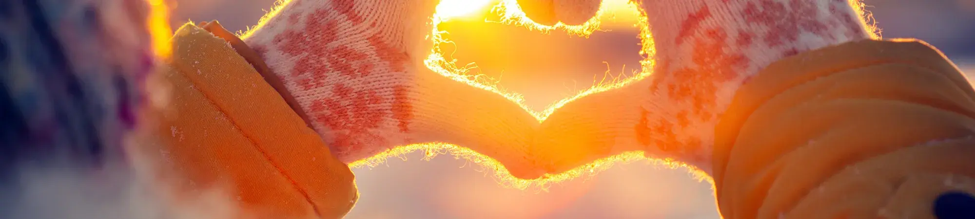 hands held up to sun in shape of a heart